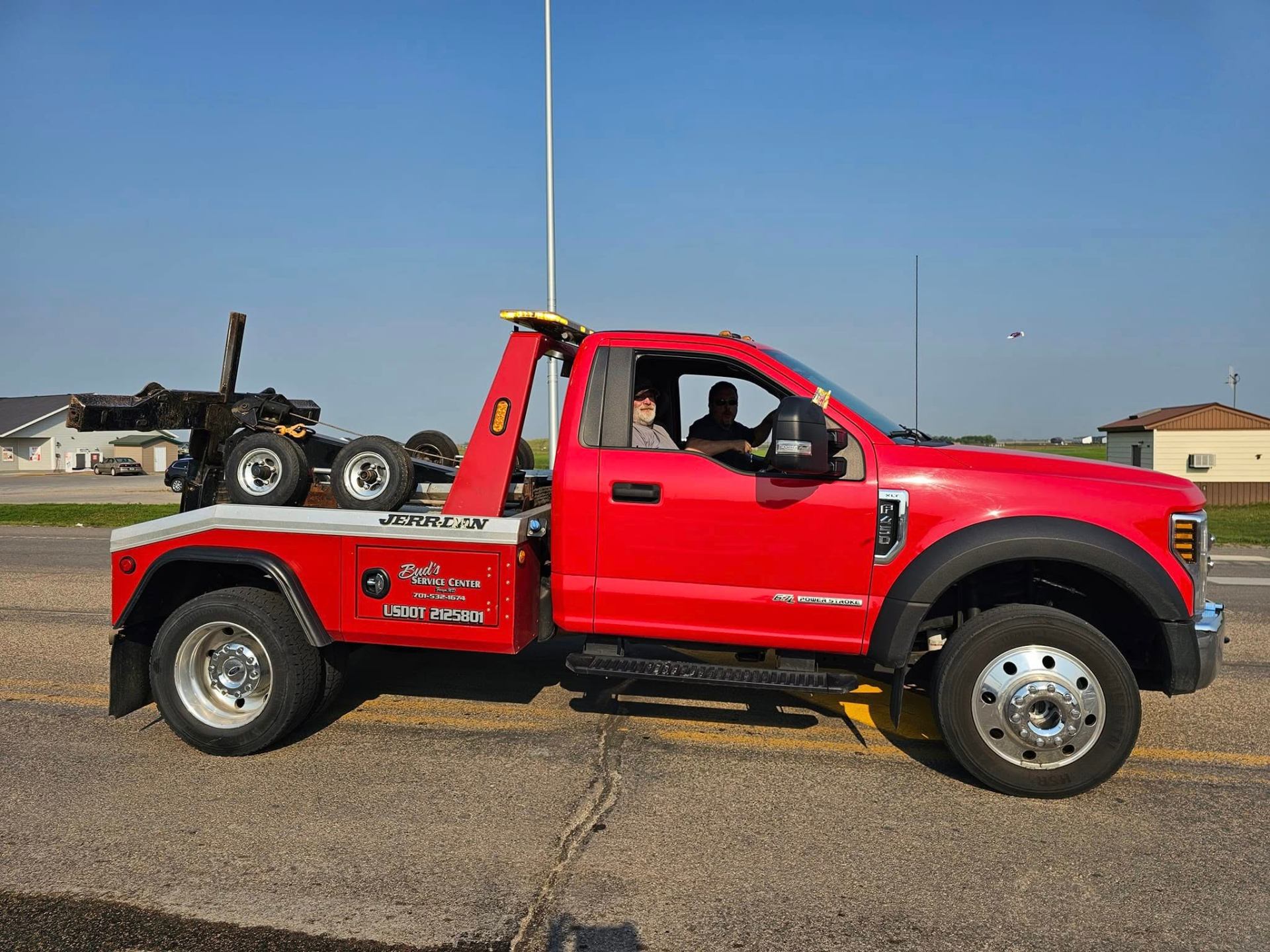 Bud's Service Center flatbed tow truck hauling motorcycles